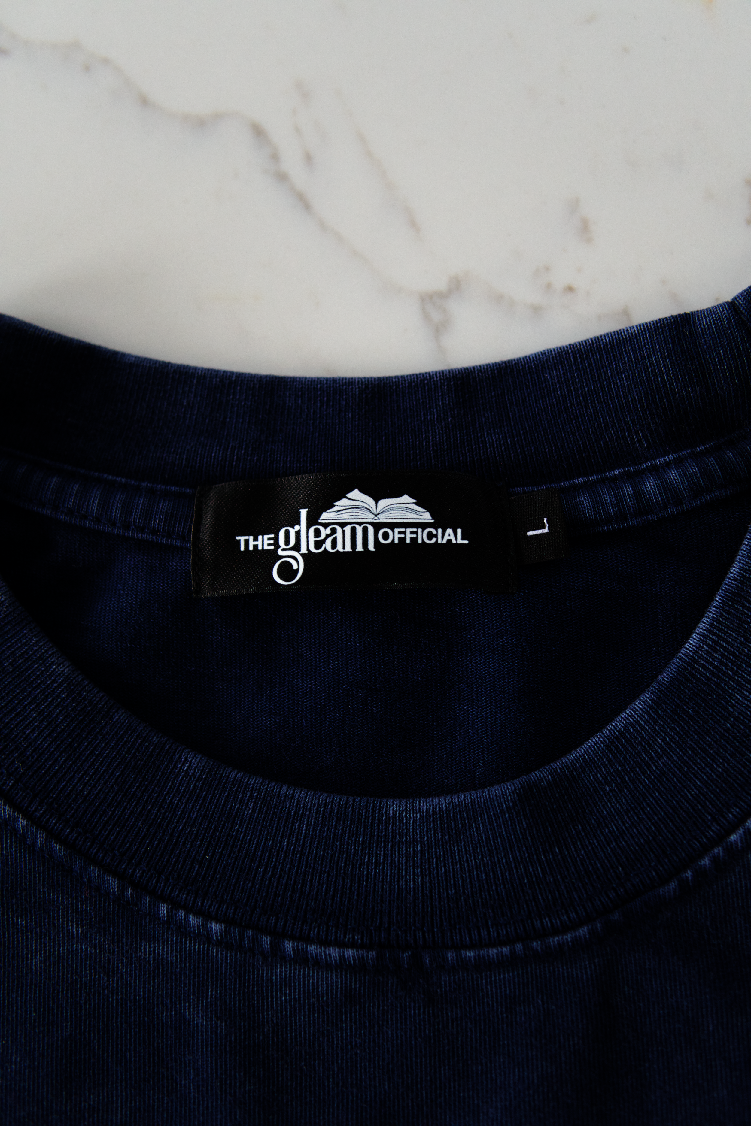 Navy blue garment with a brand label on a marble surface