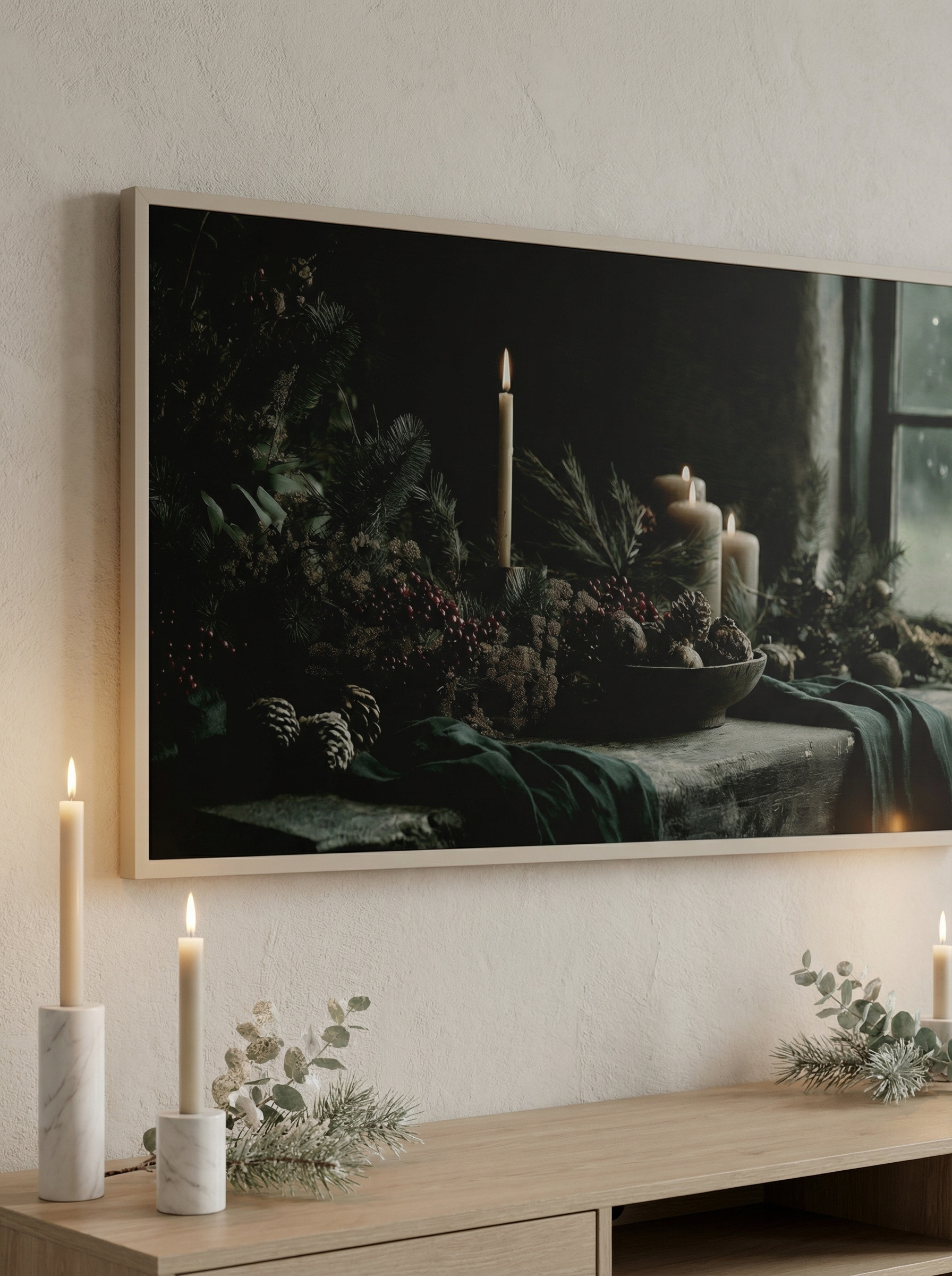 Close-up of Samsung Frame TV displaying candlelit winter still life above a wooden console with marble candle holders.